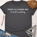 Women's funny woodworking graphic tee shirt for female woodworkers, makers, and DIY builders — Sawdust & Ponytails. Dark gray cotton tee with "TODAY IS A GOOD DAY to build something" in white text.