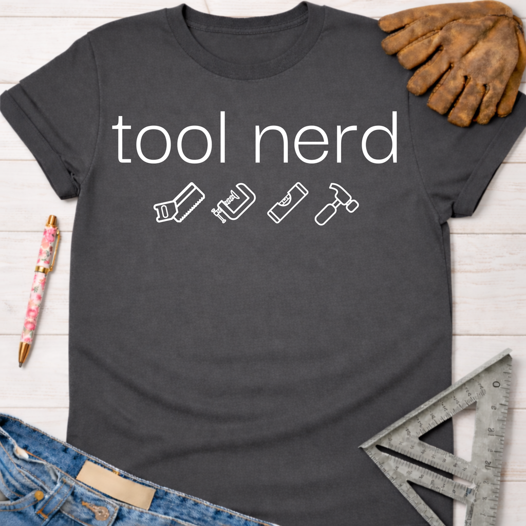 Women's funny woodworking graphic tee shirt for female woodworkers, makers, and DIY builders — Sawdust & Ponytails. Dark gray cotton t-shirt with "tool nerd" text and tool icons.