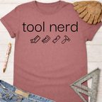 Women's funny woodworking graphic tee shirt for female woodworkers, makers, and DIY builders — Sawdust & Ponytails. Mauve cotton t-shirt with "tool nerd" text and tool icons.