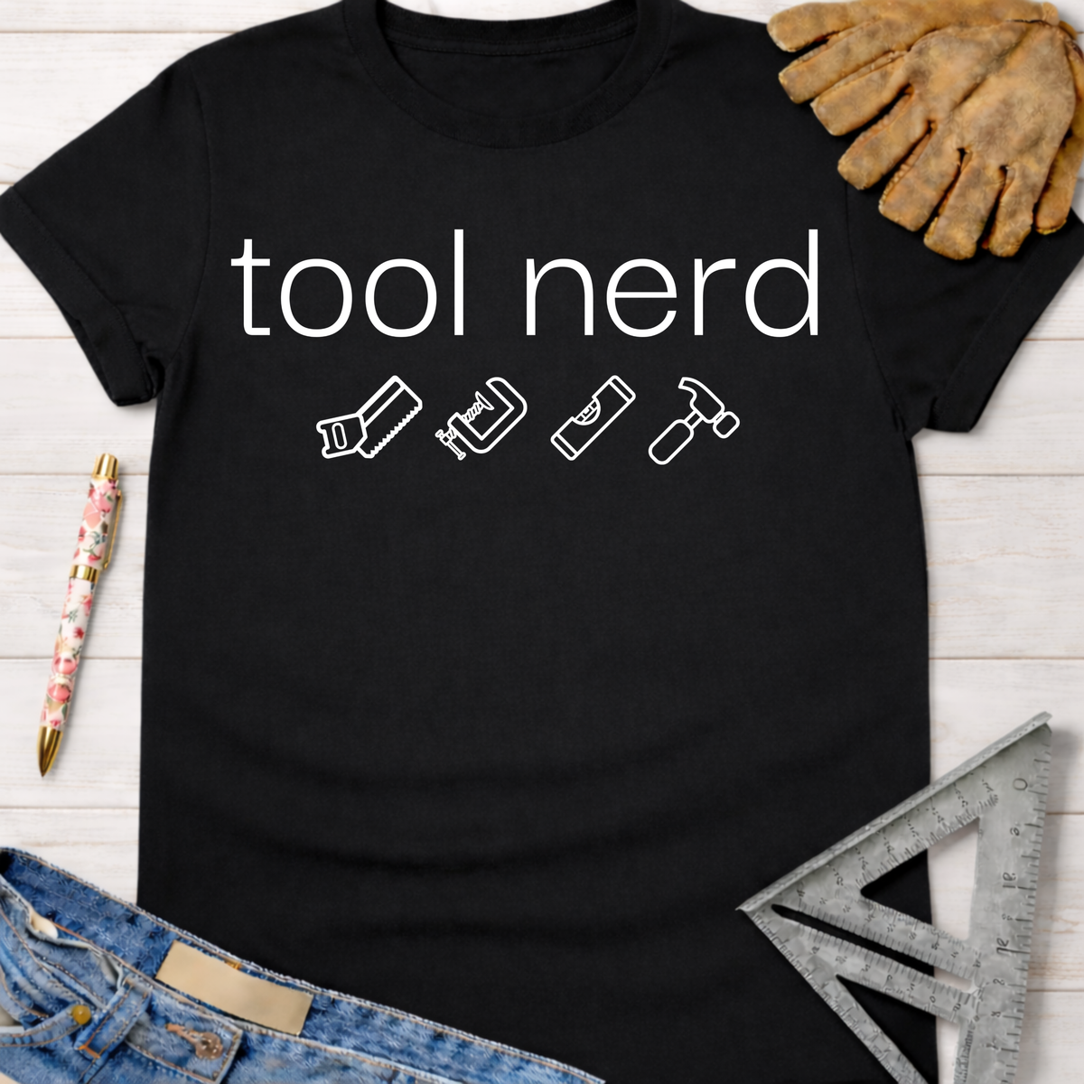 Black cotton "tool nerd" graphic tee with saw, clamp, level, and hammer icons. Women's funny woodworking graphic tee shirt for female woodworkers, makers, and DIY builders — Sawdust & Ponytails