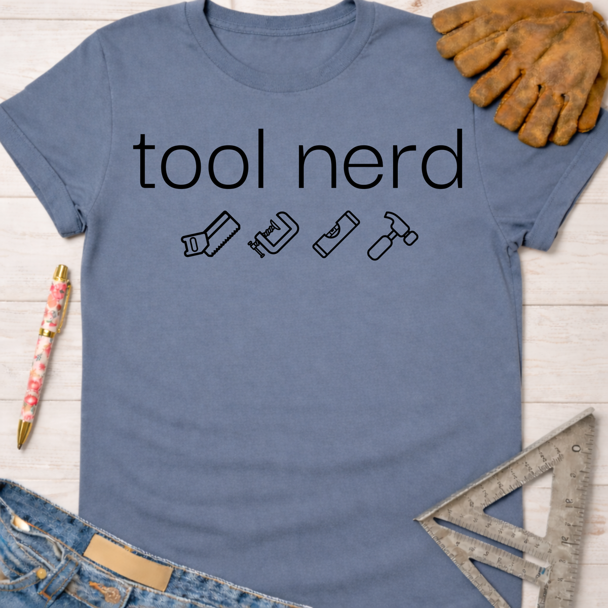 Women's funny woodworking graphic tee shirt for female woodworkers, makers, and DIY builders — Sawdust & Ponytails. Blue cotton t-shirt with "tool nerd" text and tool icons.