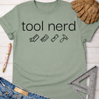 Women's funny woodworking graphic tee shirt for female woodworkers, makers, and DIY builders — Sawdust & Ponytails. Sage green cotton t-shirt with "tool nerd" text and tool icons.