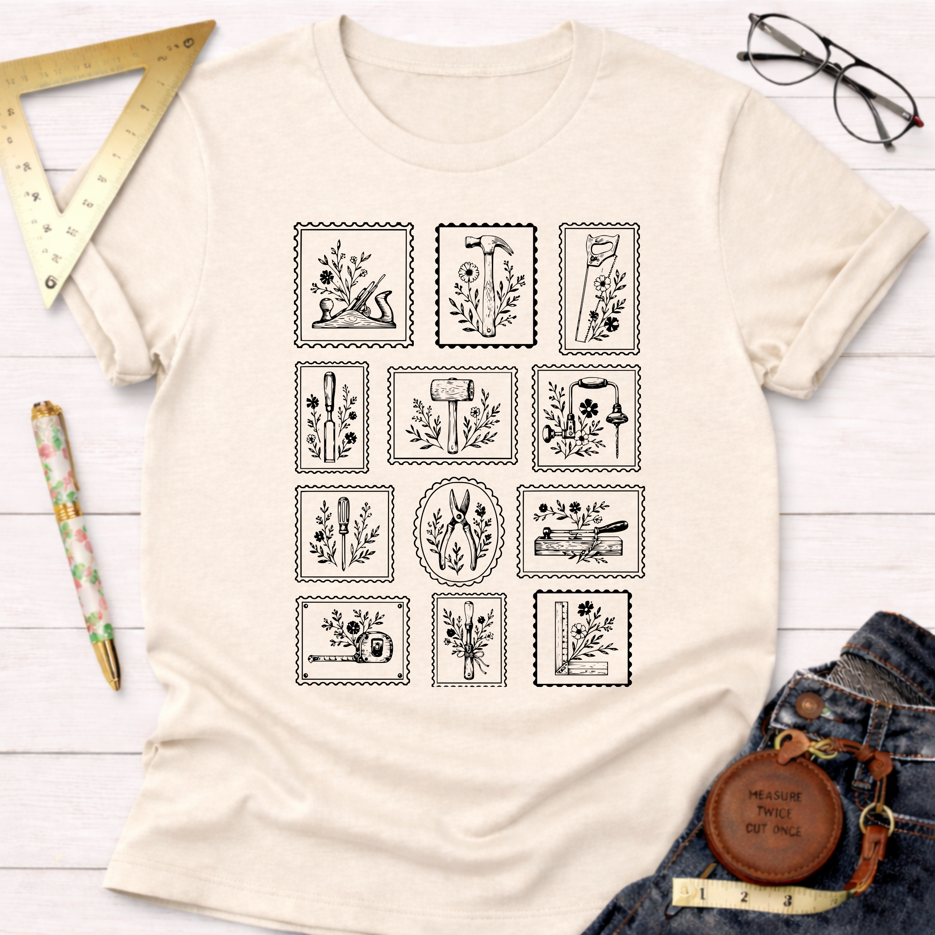 Cream "Tool Stamps" t-shirt with black woodworking tool graphics in a stamp design.