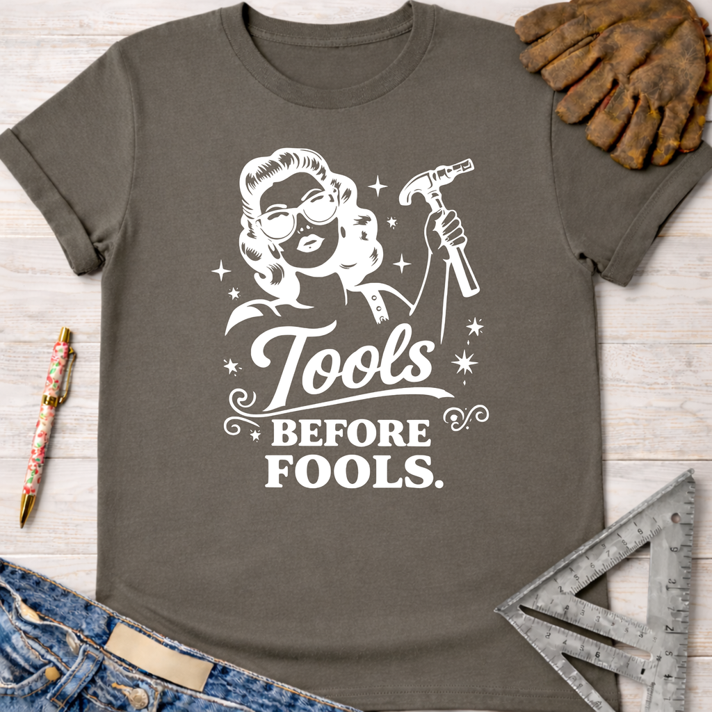 Women's funny woodworking graphic tee shirt for female woodworkers, makers, and DIY builders — Sawdust & Ponytails. Dark gray cotton tee with "Tools Before Fools" graphic.