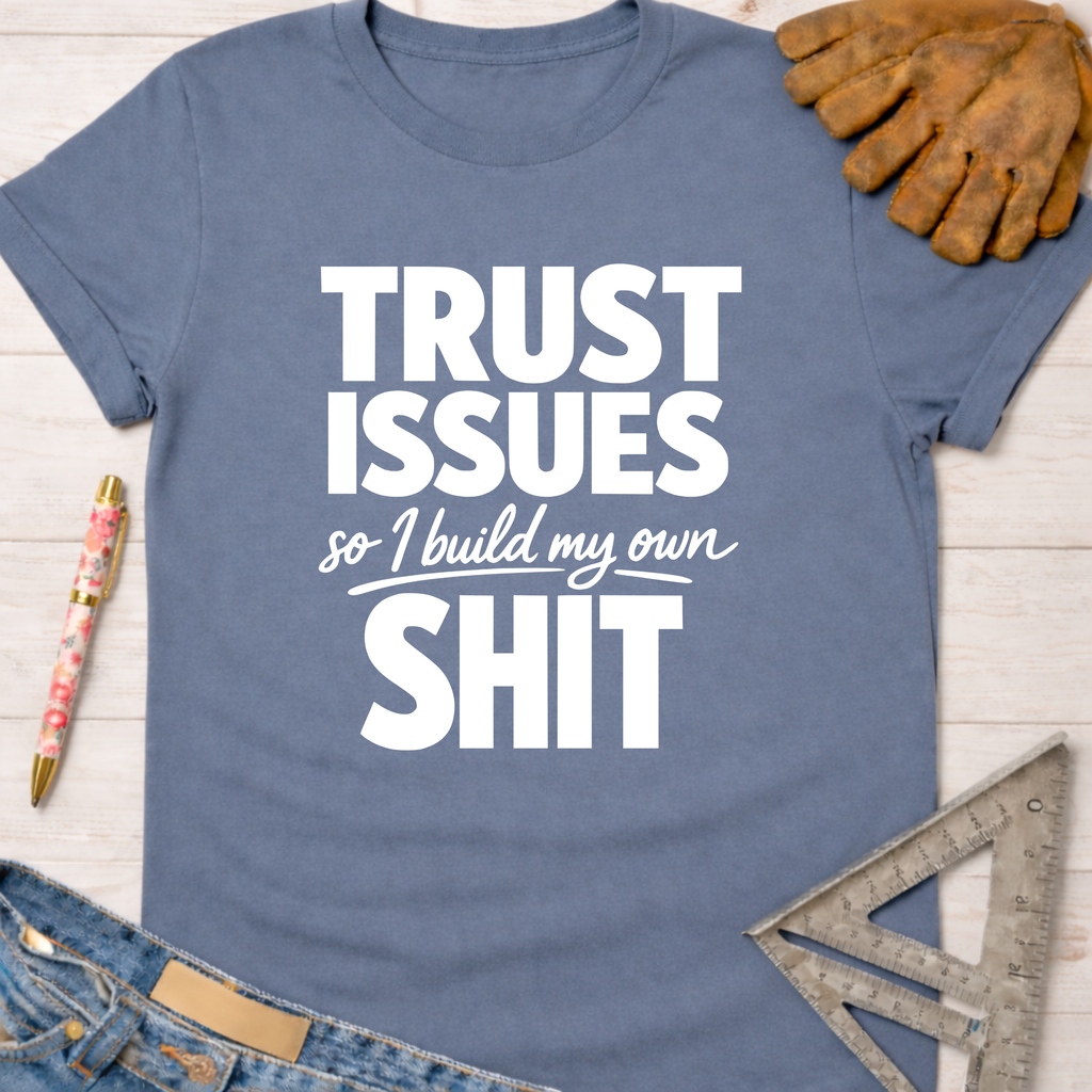 Women's funny woodworking graphic tee shirt for female woodworkers, makers, and DIY builders — Sawdust & Ponytails. Blue cotton t-shirt with "TRUST ISSUES so I build my own SHIT" in white text, surrounded by tools.