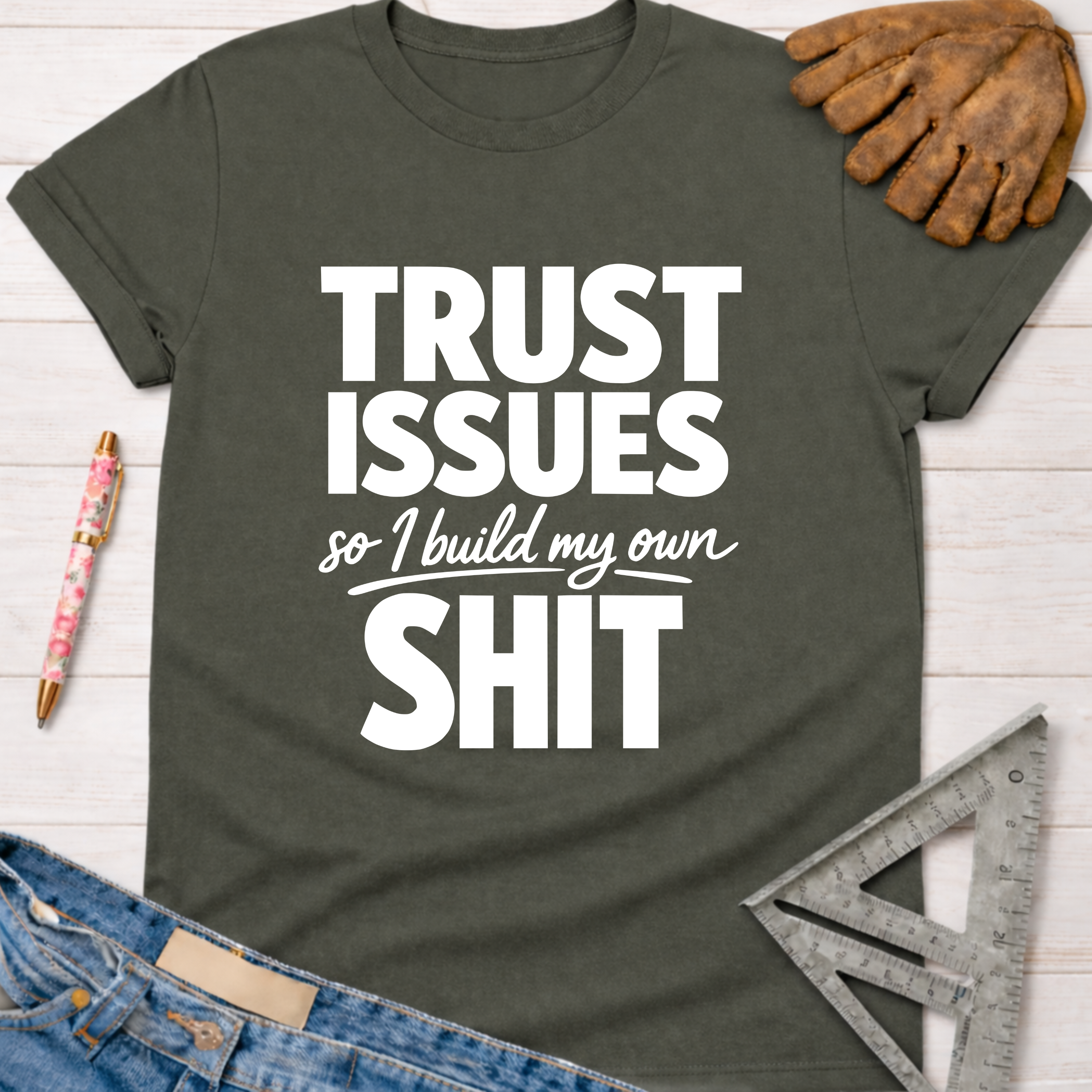 Women's funny woodworking graphic tee shirt for female woodworkers, makers, and DIY builders — Sawdust & Ponytails. Dark gray t-shirt with "TRUST ISSUES so I build my own SHIT" in white text.