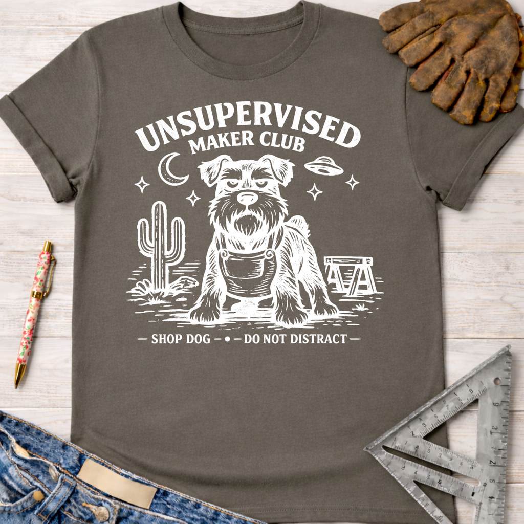 Women's funny woodworking graphic tee shirt for female woodworkers, makers, and DIY builders — Sawdust & Ponytails. Dark gray cotton tee with "Unsupervised Maker Club" and a dog in overalls.