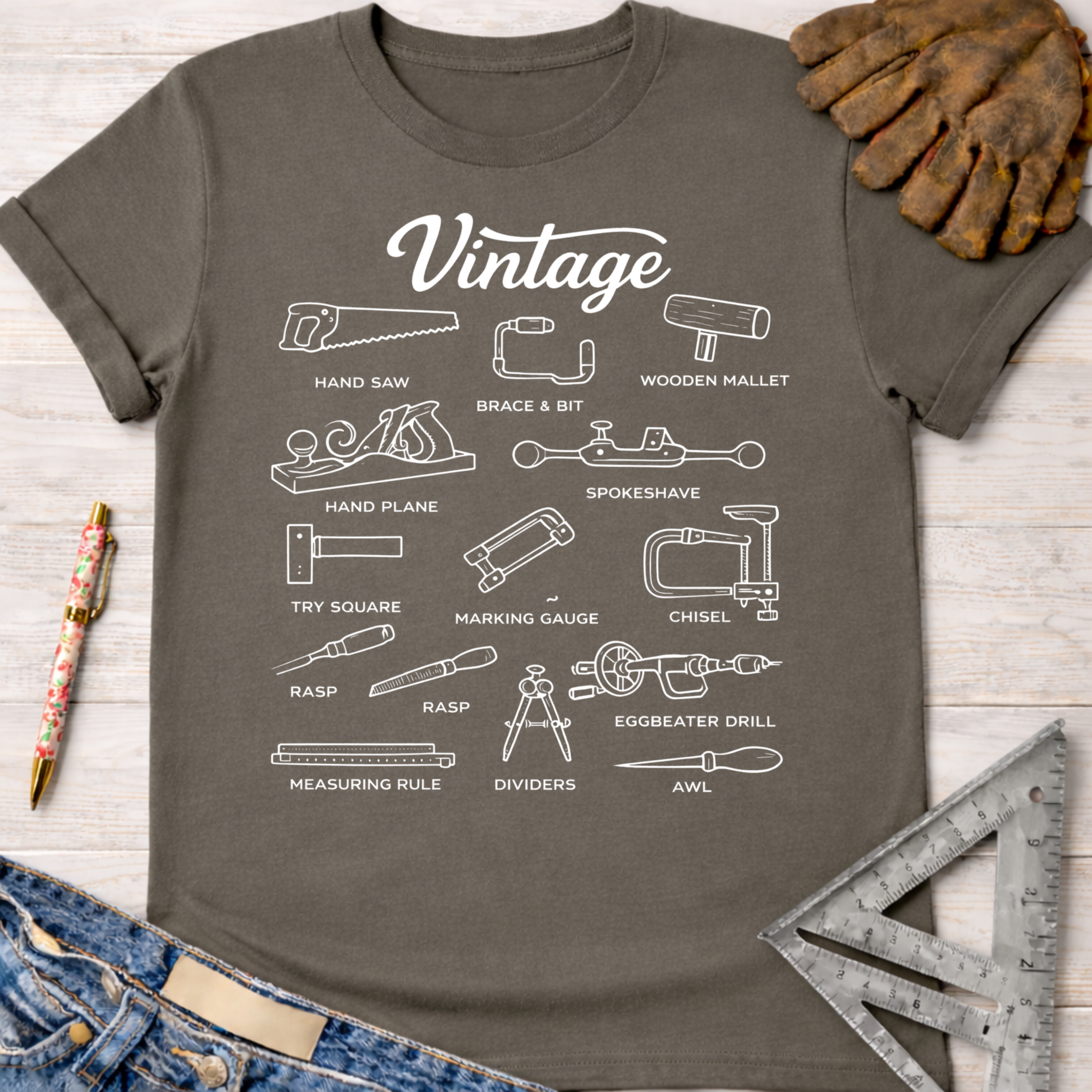Women's funny woodworking graphic tee shirt for female woodworkers, makers, and DIY builders — Sawdust & Ponytails. Dark gray cotton t-shirt with white line art of vintage woodworking tools.