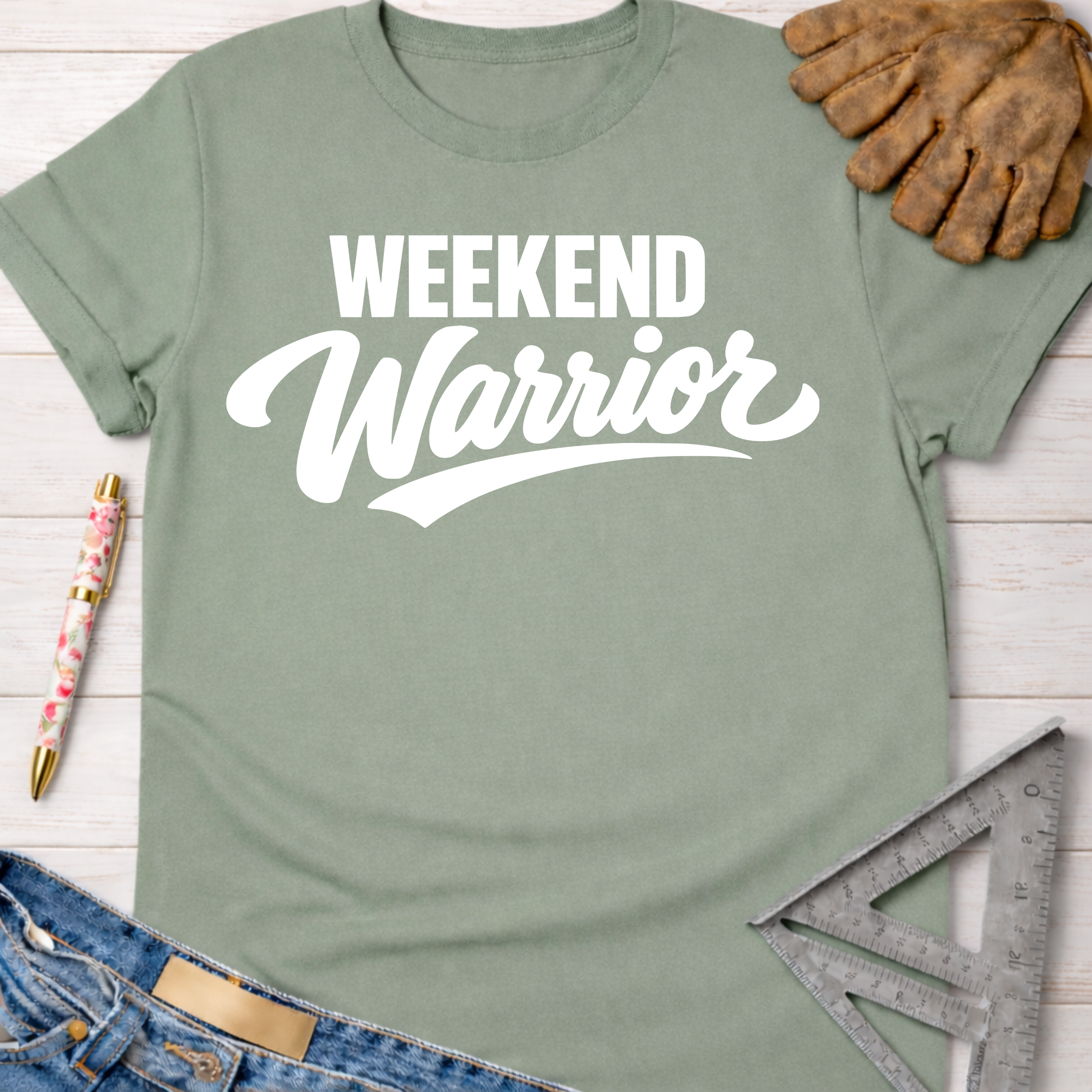 Women's funny woodworking graphic tee shirt for female woodworkers, makers, and DIY builders — Sawdust & Ponytails. Sage green cotton t-shirt with "Weekend Warrior" in white script.