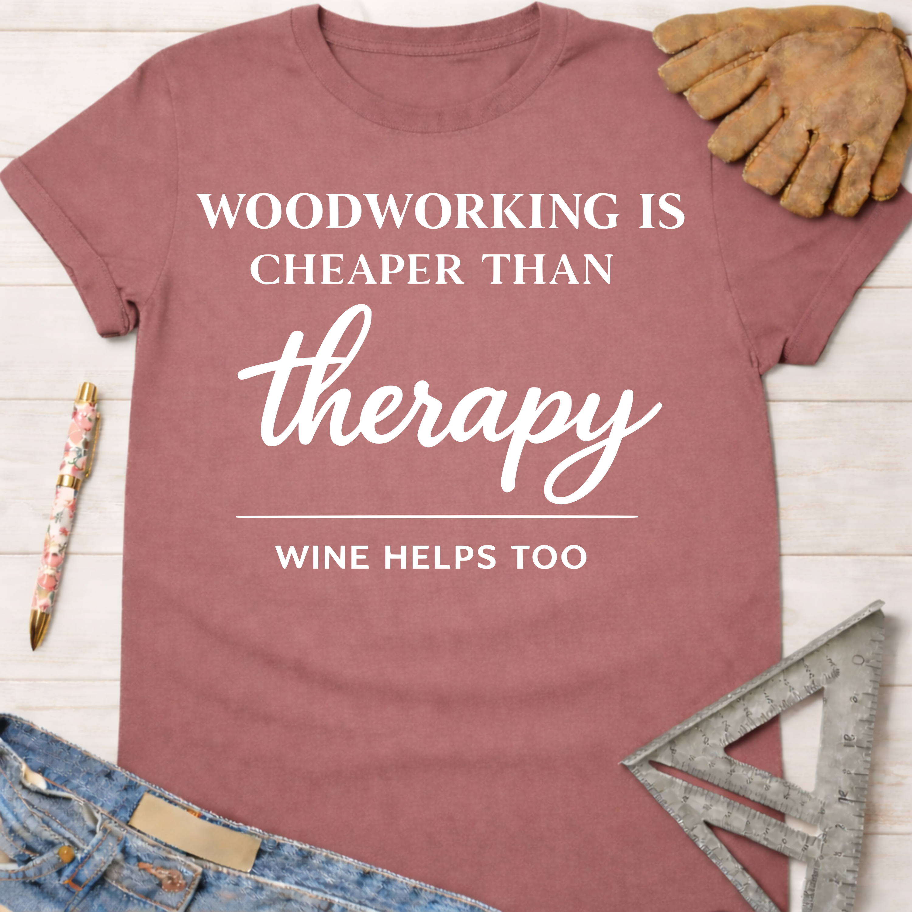 Women's funny woodworking graphic tee shirt for female woodworkers, makers, and DIY builders — Sawdust & Ponytails. Mauve cotton tee with "Woodworking is cheaper than therapy, wine helps too" text.