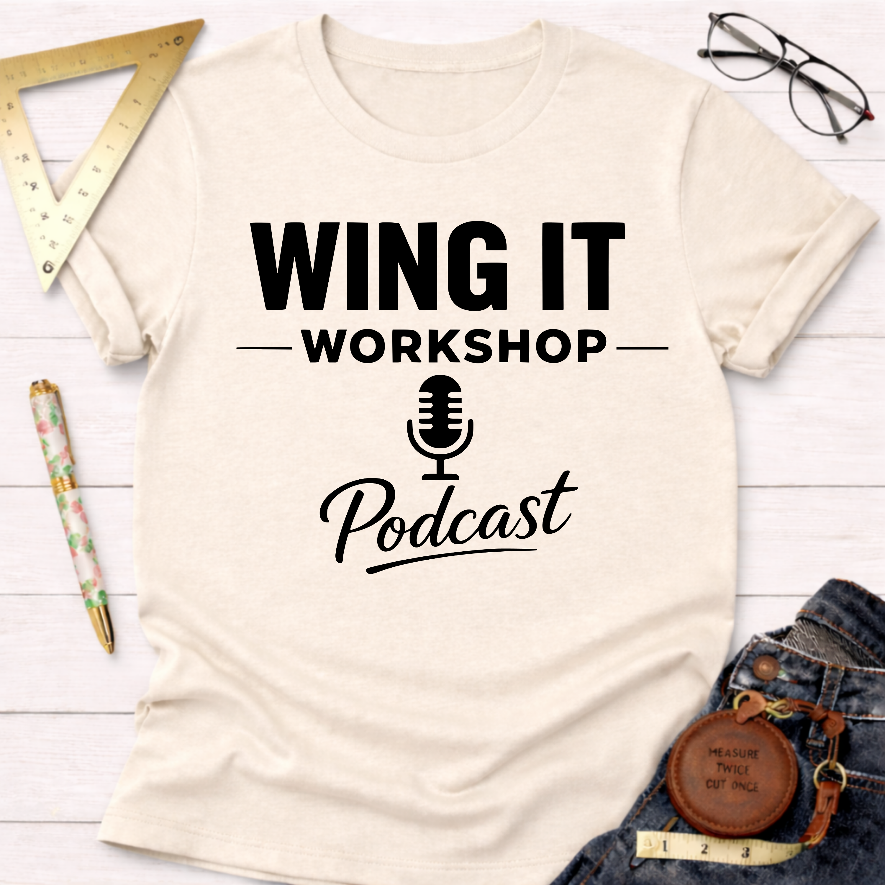 Cream cotton t-shirt with "WING IT WORKSHOP Podcast" in black text and a microphone icon.