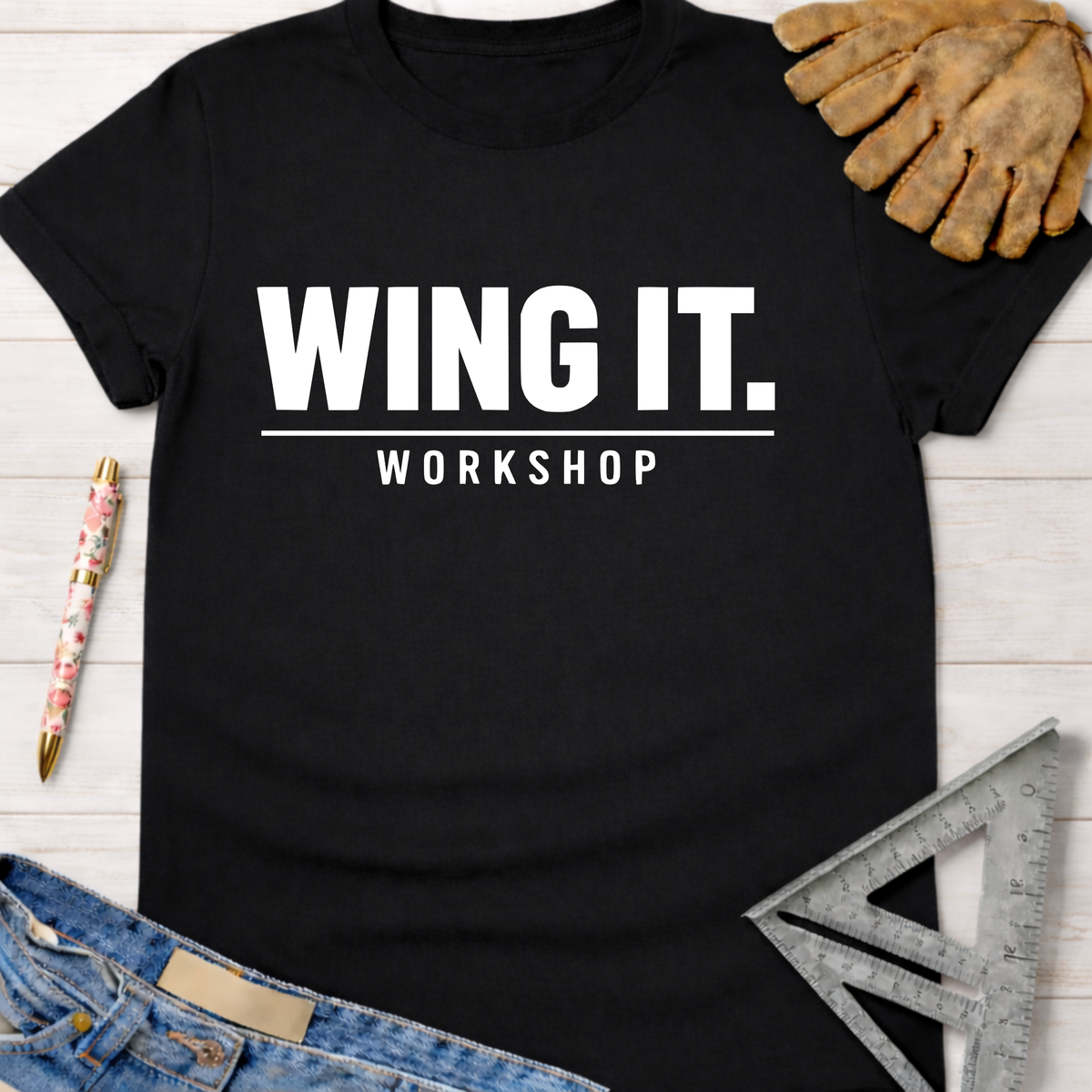 Black cotton "WING IT. WORKSHOP" graphic tee with work gloves, jeans, and ruler. Women's funny woodworking graphic tee shirt for female woodworkers, makers, and DIY builders — Sawdust & Ponytails