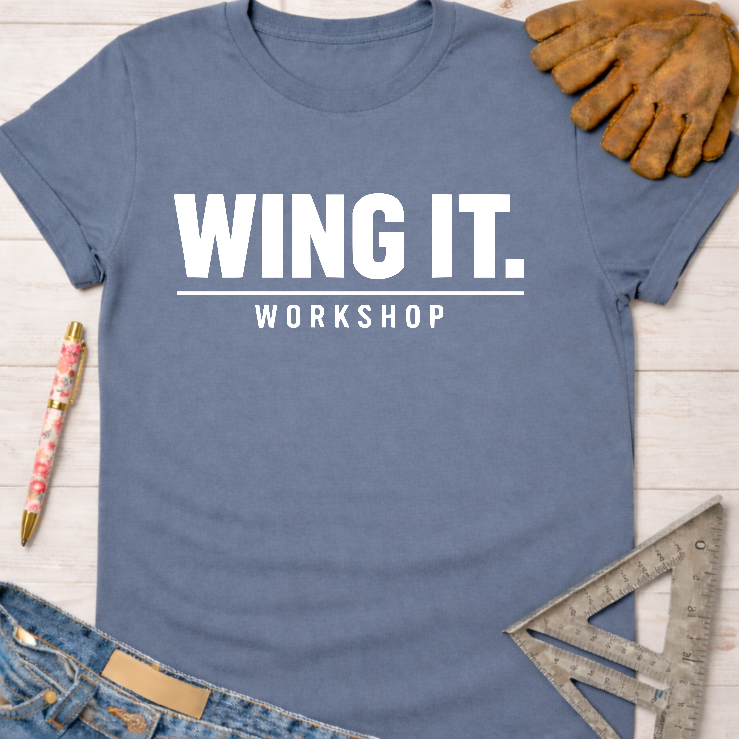 Women's funny woodworking graphic tee shirt for female woodworkers, makers, and DIY builders — Sawdust & Ponytails. Blue cotton tee with "WING IT. WORKSHOP" in white text.