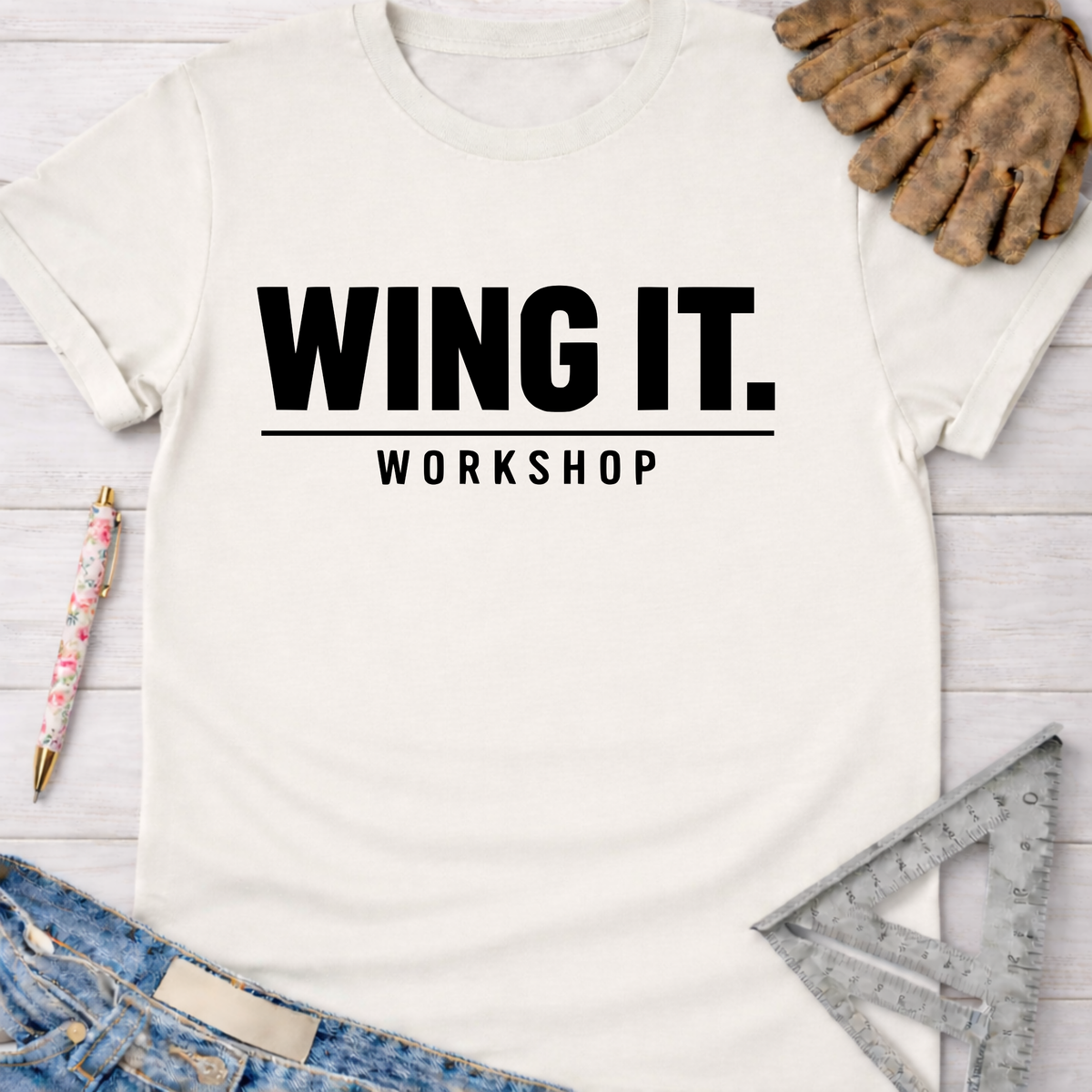 Women's funny woodworking graphic tee shirt for female woodworkers, makers, and DIY builders — Sawdust & Ponytails. Cream t-shirt with "WING IT. WORKSHOP" in black text.