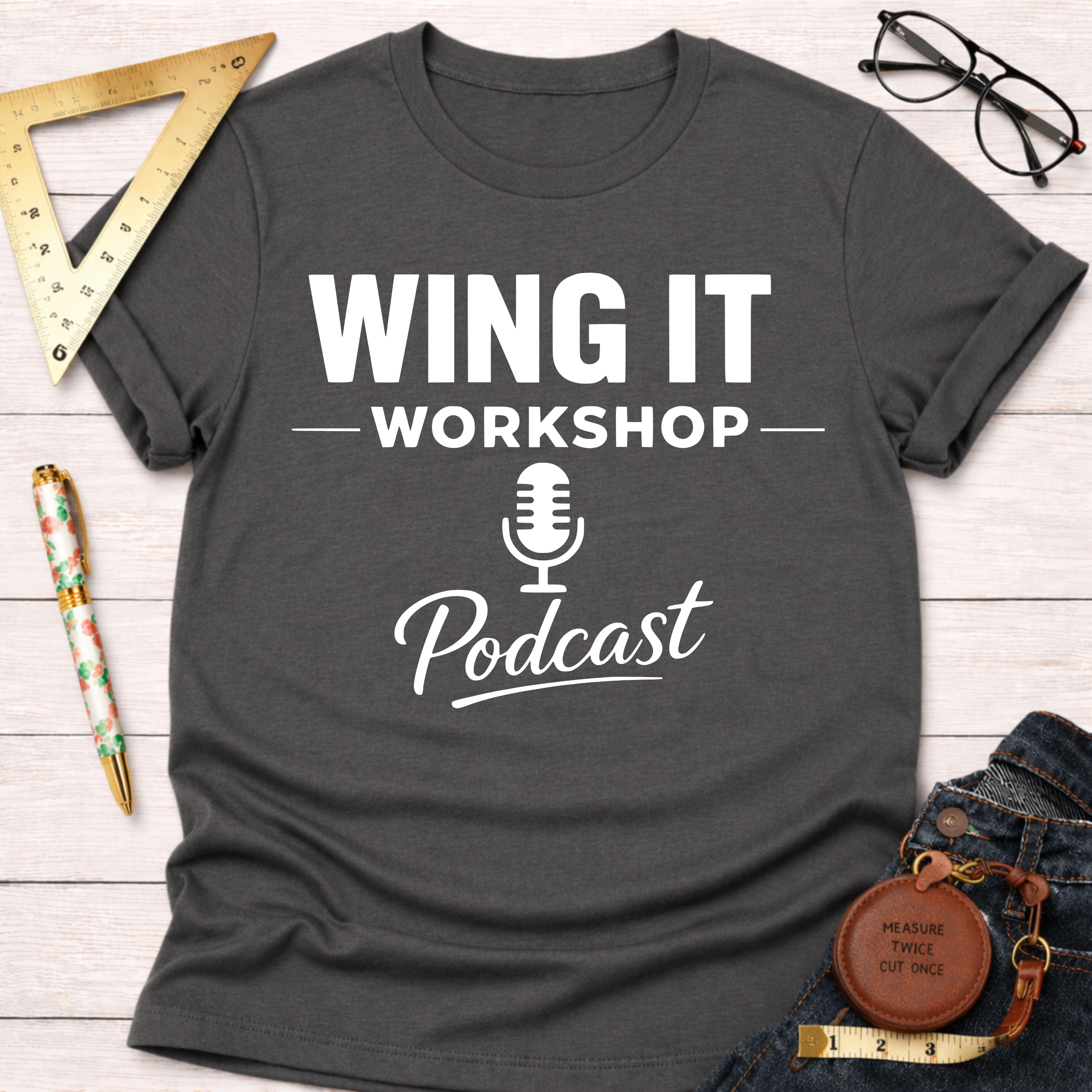 Charcoal gray cotton t-shirt with "WING IT WORKSHOP Podcast" in white text and a microphone icon.