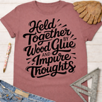 Women's funny woodworking graphic tee shirt for female woodworkers, makers, and DIY builders — Sawdust & Ponytails. Mauve t-shirt with "Held Together by Wood Glue and Impure Thoughts" in black script.