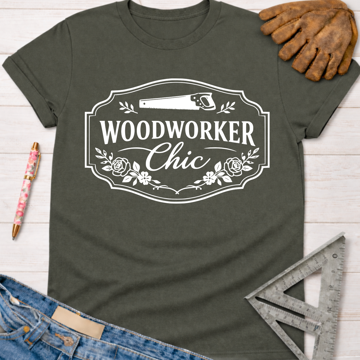 Women's funny woodworking graphic tee shirt for female woodworkers, makers, and DIY builders — Sawdust & Ponytails. Dark gray cotton tee with "Woodworker Chic" text, saw, and floral design.