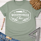 Sage green women's "Woodworker Chic" graphic tee with saw and floral design. Women's funny woodworking graphic tee shirt for female woodworkers, makers, and DIY builders — Sawdust & Ponytails.
