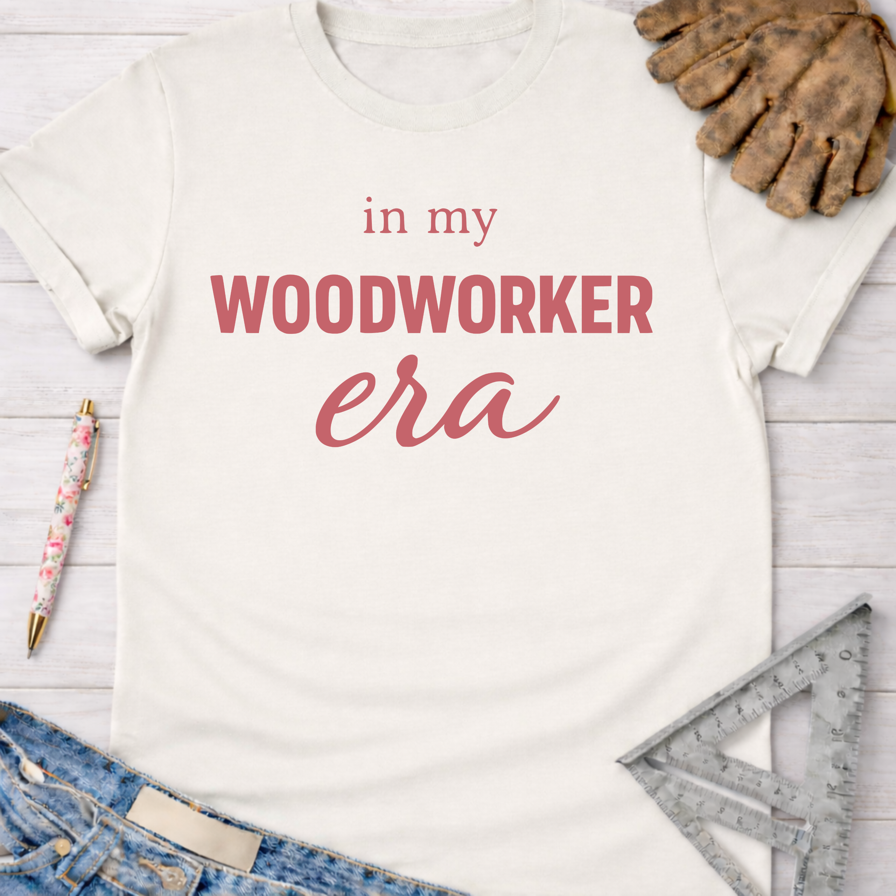 Women's funny woodworking graphic tee shirt for female woodworkers, makers, and DIY builders — Sawdust & Ponytails. Cream t-shirt with "in my WOODWORKER era" in pink text.