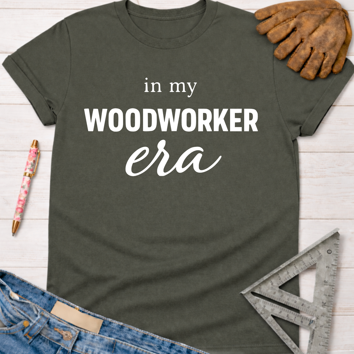 Women's funny woodworking graphic tee shirt for female woodworkers, makers, and DIY builders — Sawdust & Ponytails. Dark gray short-sleeve t-shirt with "in my WOODWORKER era" text.