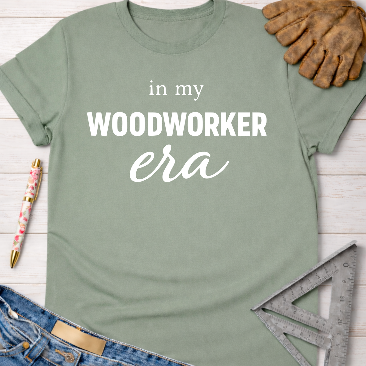 Women's funny woodworking graphic tee shirt for female woodworkers, makers, and DIY builders — Sawdust & Ponytails. Sage green cotton tee with "in my WOODWORKER era" text.