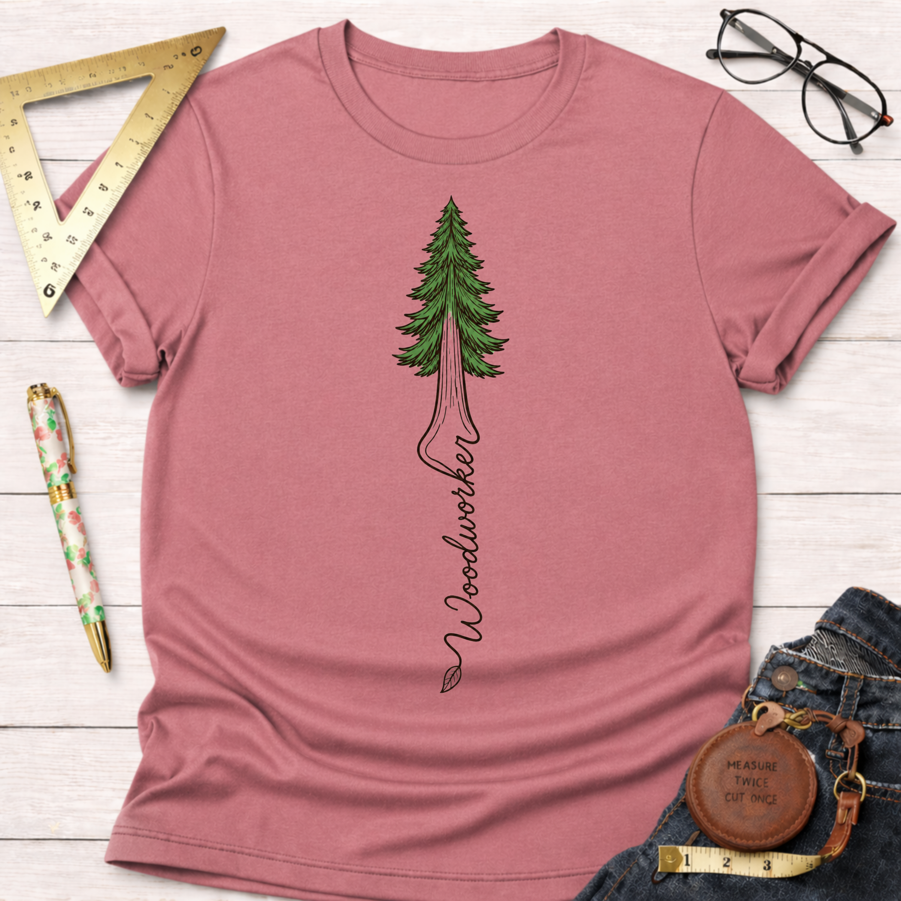 Women's funny woodworking graphic tee shirt for female woodworkers, makers, and DIY builders — Sawdust & Ponytails. Dusty rose crewneck t-shirt with a green redwood tree graphic and "Woodworker" text.