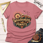 Pink cotton "Woodworking Awaits" t-shirt with a graphic of mountains, a saw sun, and a hand plane.