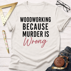 Off-white cotton t-shirt with "WOODWORKING BECAUSE MURDER IS Wrong" in black and pink script.
