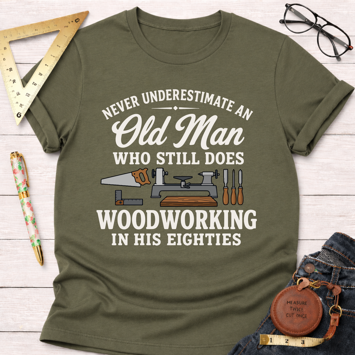 Olive green "Never Underestimate An Old Man Who Still Does Woodworking In His Eighties" t-shirt with tools.