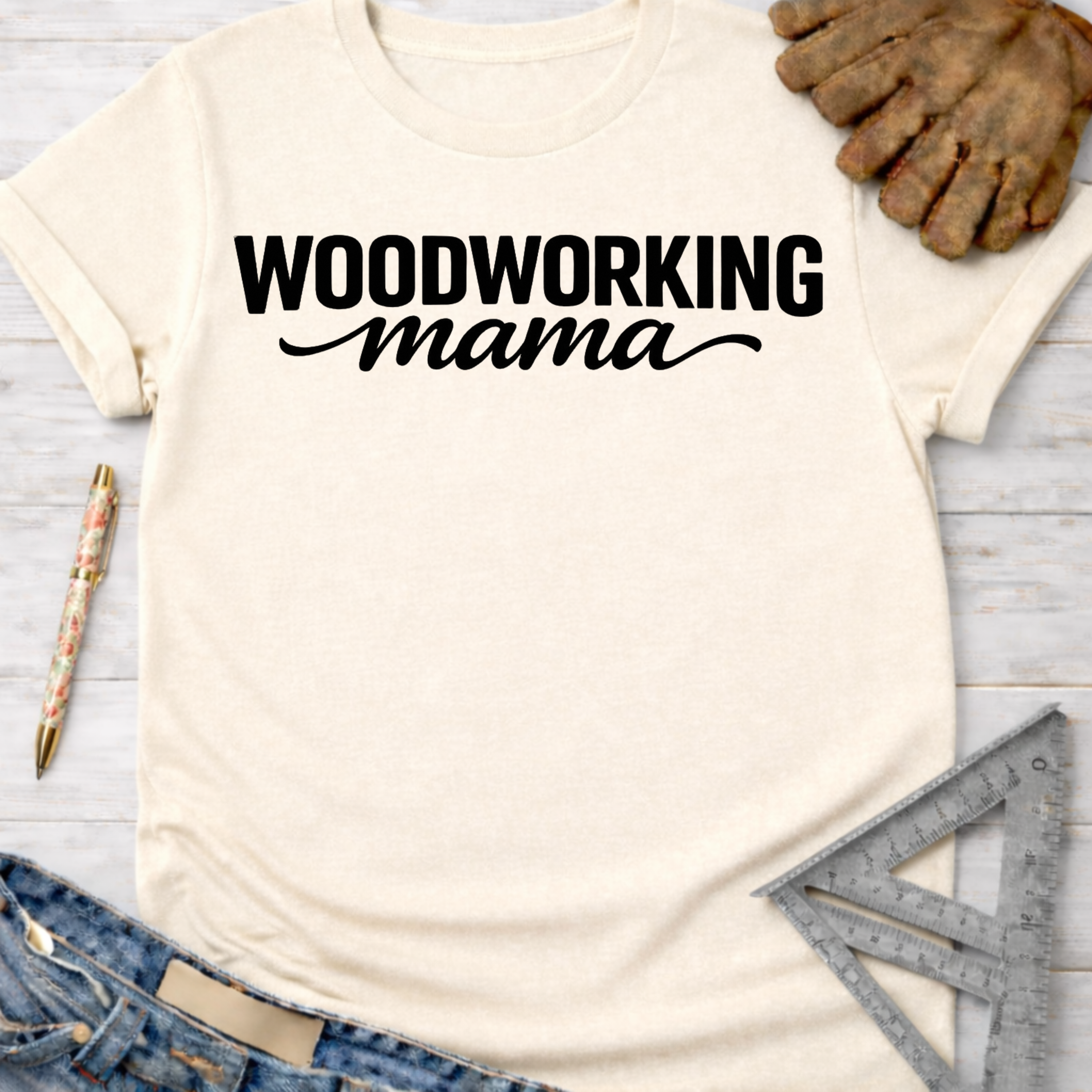 Women's funny woodworking graphic tee shirt for female woodworkers, makers, and DIY builders — Sawdust & Ponytails. Cream t-shirt with "WOODWORKING mama" in black text.
