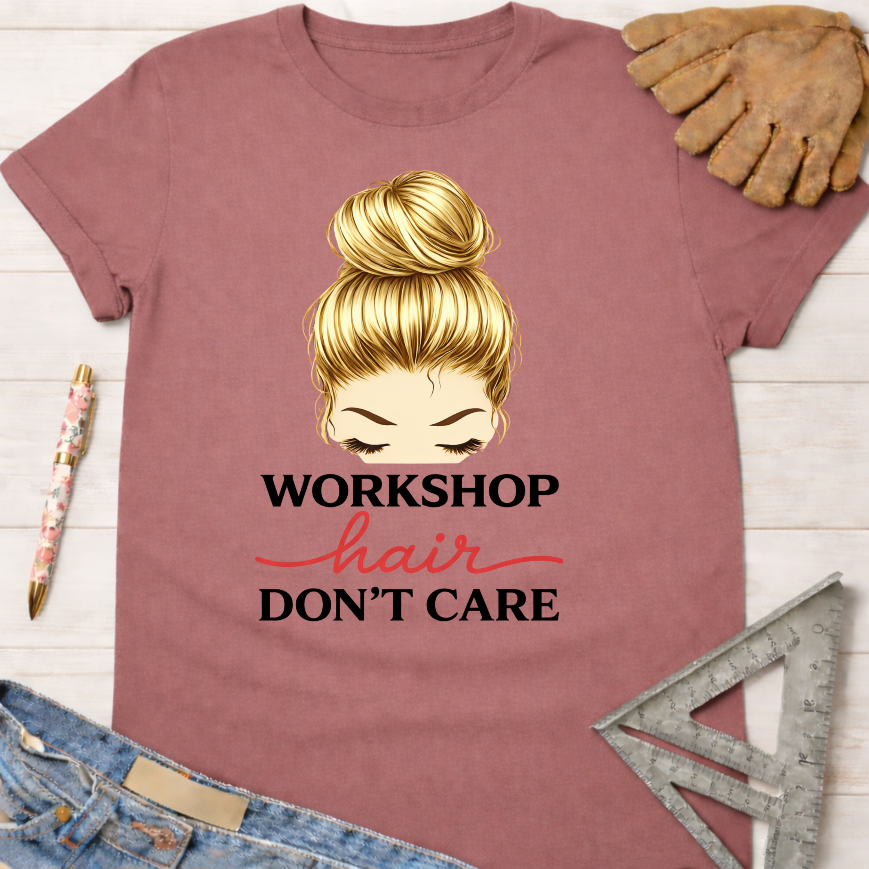 Women's funny woodworking graphic tee shirt for female woodworkers, makers, and DIY builders — Sawdust & Ponytails. Mauve t-shirt with blonde messy bun graphic and "Workshop Hair Don't Care" text.