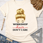 Women's funny woodworking graphic tee shirt for female woodworkers, makers, and DIY builders — Sawdust & Ponytails. Cream t-shirt with "Workshop Hair Don't Care" graphic.