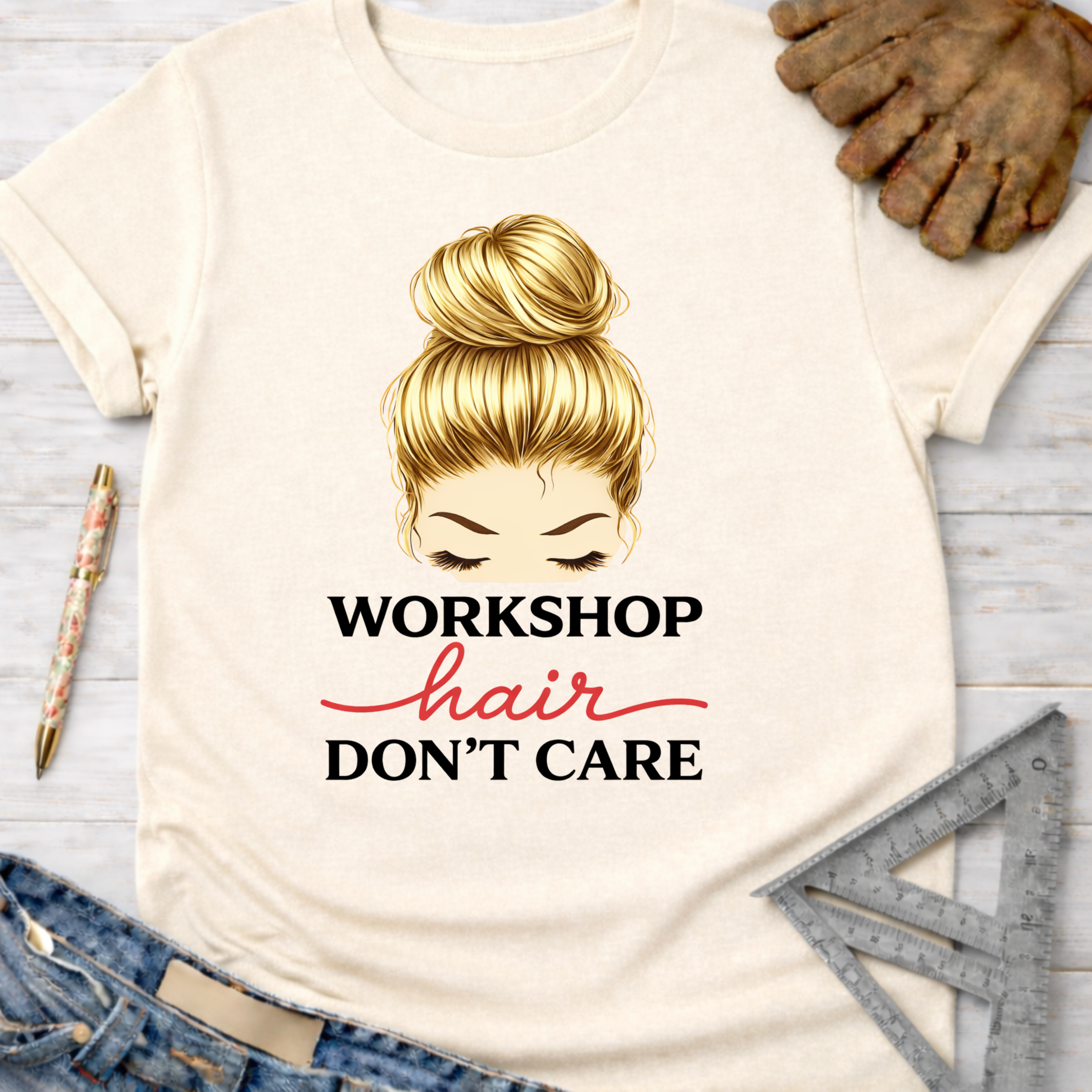 Women's funny woodworking graphic tee shirt for female woodworkers, makers, and DIY builders — Sawdust & Ponytails. Cream t-shirt with "Workshop Hair Don't Care" graphic.