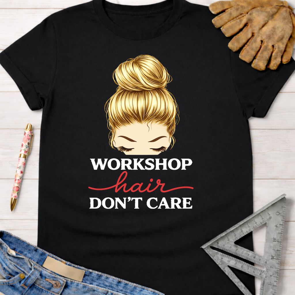 Women's funny woodworking graphic tee shirt for female woodworkers, makers, and DIY builders — Sawdust & Ponytails. Black cotton tee with "Workshop Hair Don't Care" graphic and blonde messy bun.