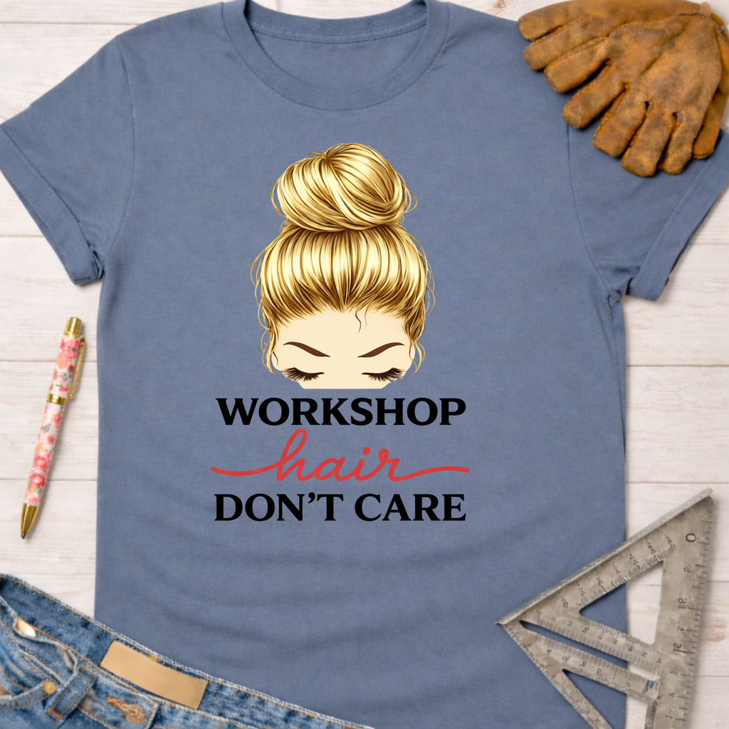 Women's funny woodworking graphic tee shirt for female woodworkers, makers, and DIY builders — Sawdust & Ponytails. Blue cotton tee with "Workshop Hair Don't Care" graphic, featuring a blonde messy bun.