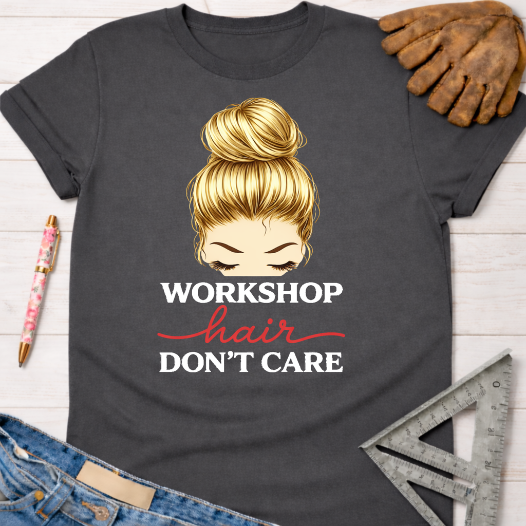 Women's funny woodworking graphic tee shirt for female woodworkers, makers, and DIY builders — Sawdust & Ponytails. Dark gray t-shirt with blonde messy bun graphic and "Workshop Hair Don't Care" text.