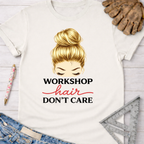 Women's funny woodworking graphic tee shirt for female woodworkers, makers, and DIY builders — Sawdust & Ponytails. White cotton t-shirt with "Workshop Hair Don't Care" text and a blonde messy bun illustration.