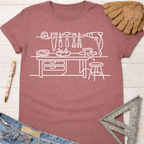 Women's funny woodworking graphic tee shirt for female woodworkers, makers, and DIY builders — Sawdust & Ponytails. Mauve cotton tee with white line art workshop tools.