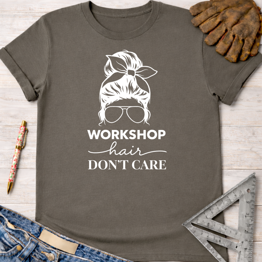 Women's funny woodworking graphic tee shirt for female woodworkers, makers, and DIY builders — Sawdust & Ponytails. Charcoal gray cotton tee with "Workshop Hair Don't Care" graphic.