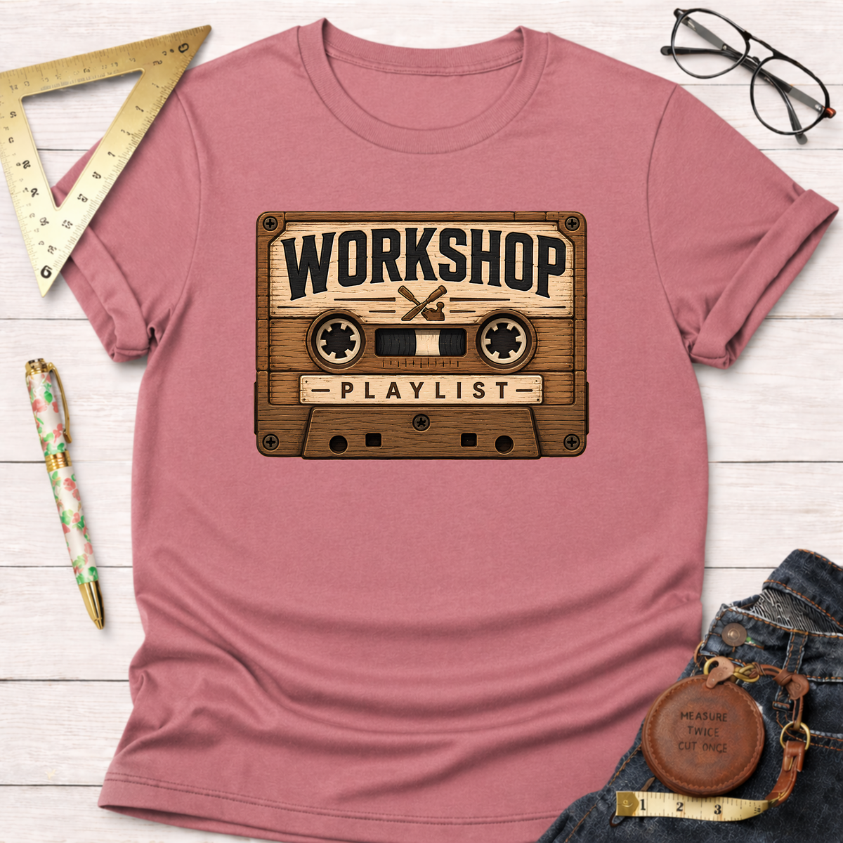 Pink t-shirt with a vintage wooden cassette tape graphic featuring "WORKSHOP PLAYLIST" text.