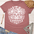 Women's funny woodworking graphic tee shirt for female woodworkers, makers, and DIY builders — Sawdust & Ponytails. Mauve t-shirt with white floral skull and tools graphic.
