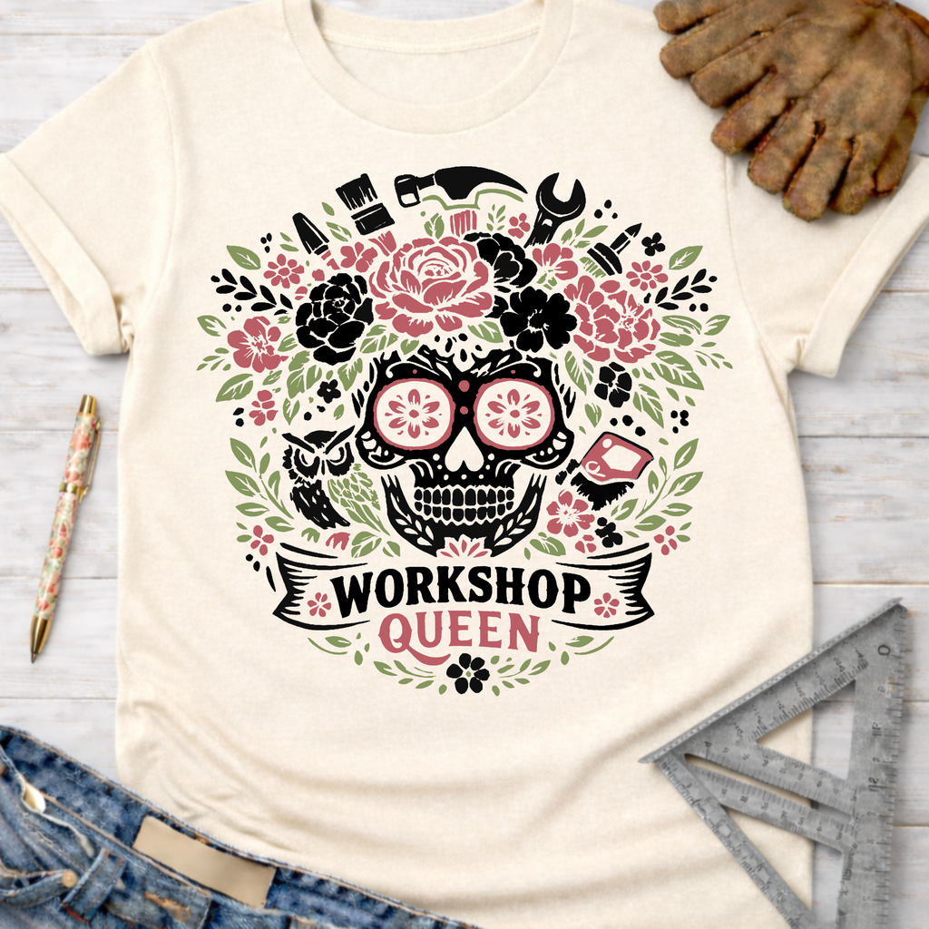 Women's funny woodworking graphic tee shirt for female woodworkers, makers, and DIY builders — Sawdust & Ponytails. Cream t-shirt with a floral skull and tools graphic, "Workshop Queen" banner.