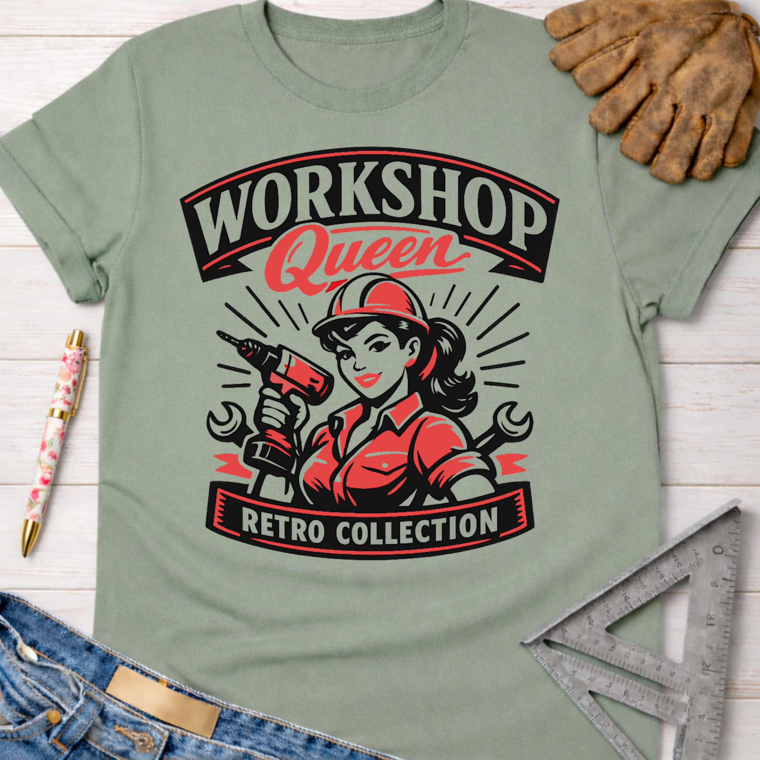 Sage green cotton "Workshop Queen Retro Collection" tee with a female woodworker graphic, paired with jeans and work gloves. Women's funny woodworking graphic tee shirt for female woodworkers, makers, and DIY builders — Sawdust & Ponytails
