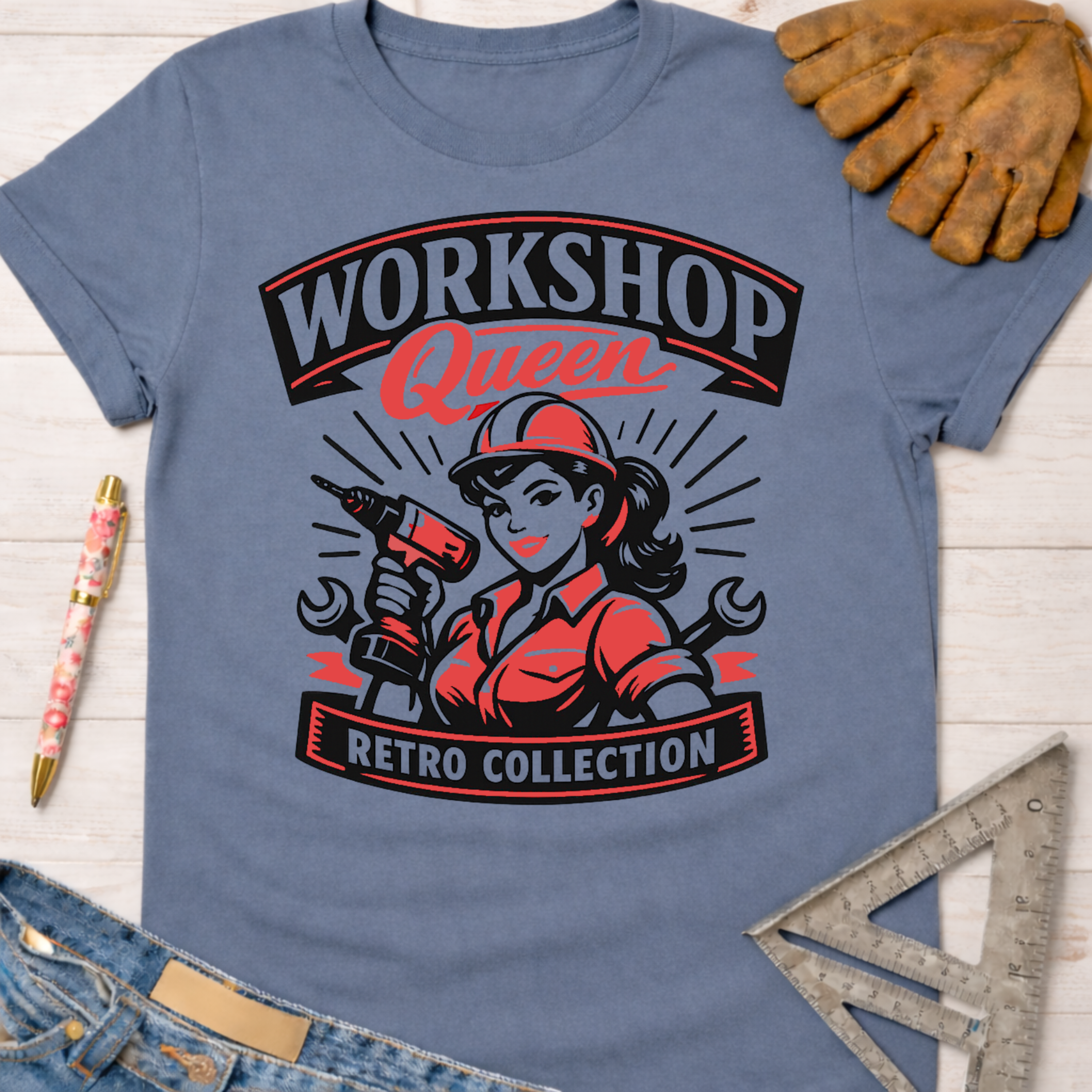 Women's funny woodworking graphic tee shirt for female woodworkers, makers, and DIY builders — Sawdust & Ponytails. Blue cotton t-shirt with "Workshop Queen Retro Collection" graphic featuring a woman in a hard hat holding a drill.