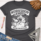 Charcoal gray cotton "Workshop Queen Retro Collection" graphic tee with a female builder holding a drill, next to work gloves and jeans. Women's funny woodworking graphic tee shirt for female woodworkers, makers, and DIY builders — Sawdust & Ponytails