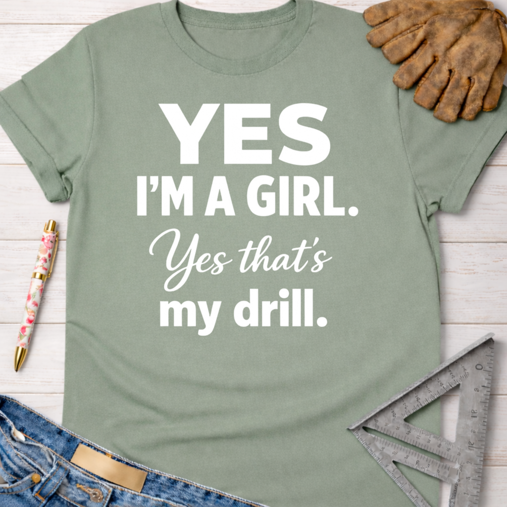 Women's funny woodworking graphic tee shirt for female woodworkers, makers, and DIY builders — Sawdust & Ponytails. Sage green cotton tee with "Yes I'm a Girl. Yes that's my drill." in white text.