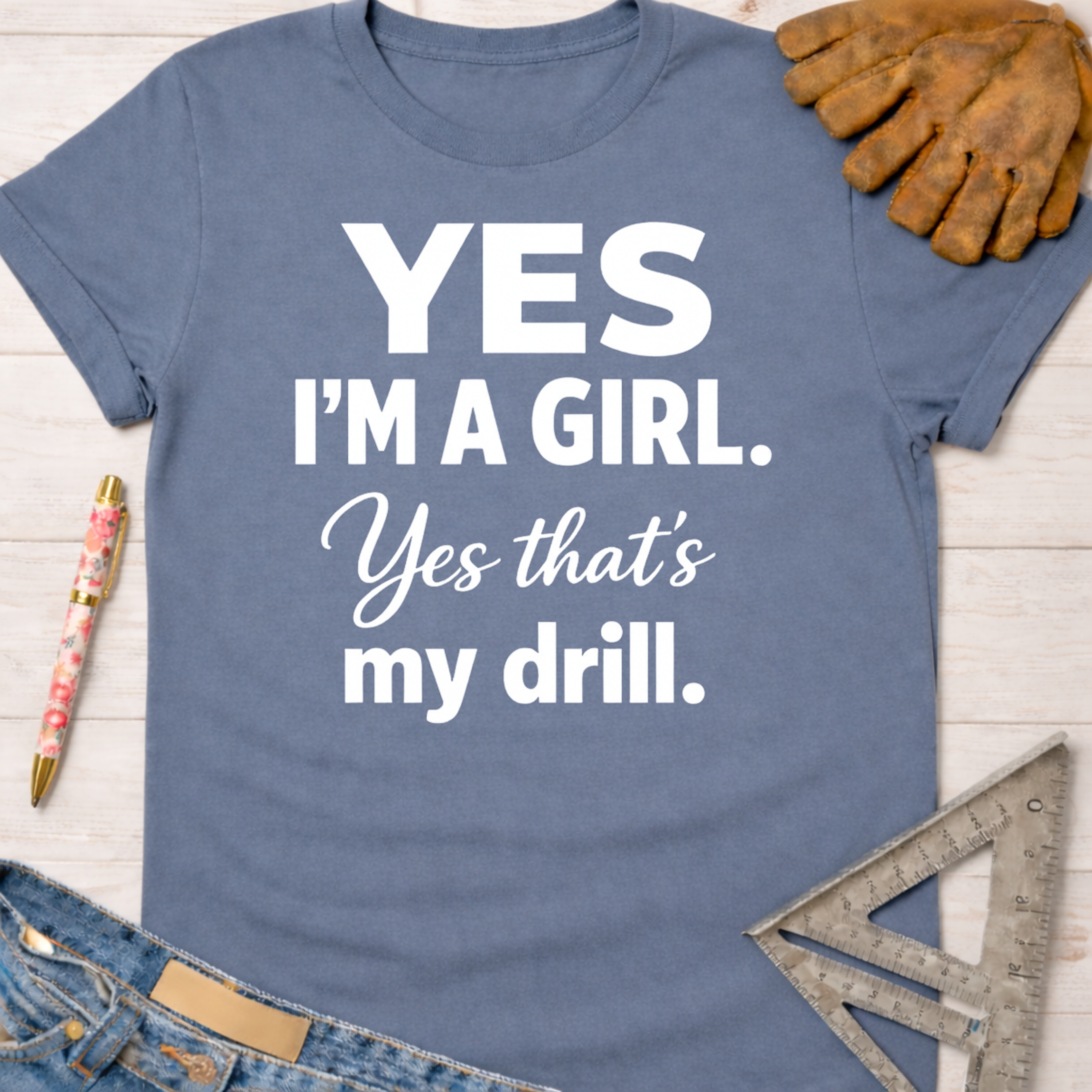 Women's funny woodworking graphic tee shirt for female woodworkers, makers, and DIY builders — Sawdust & Ponytails. Blue cotton tee with "Yes I'm a Girl. Yes that's my drill." in white text.