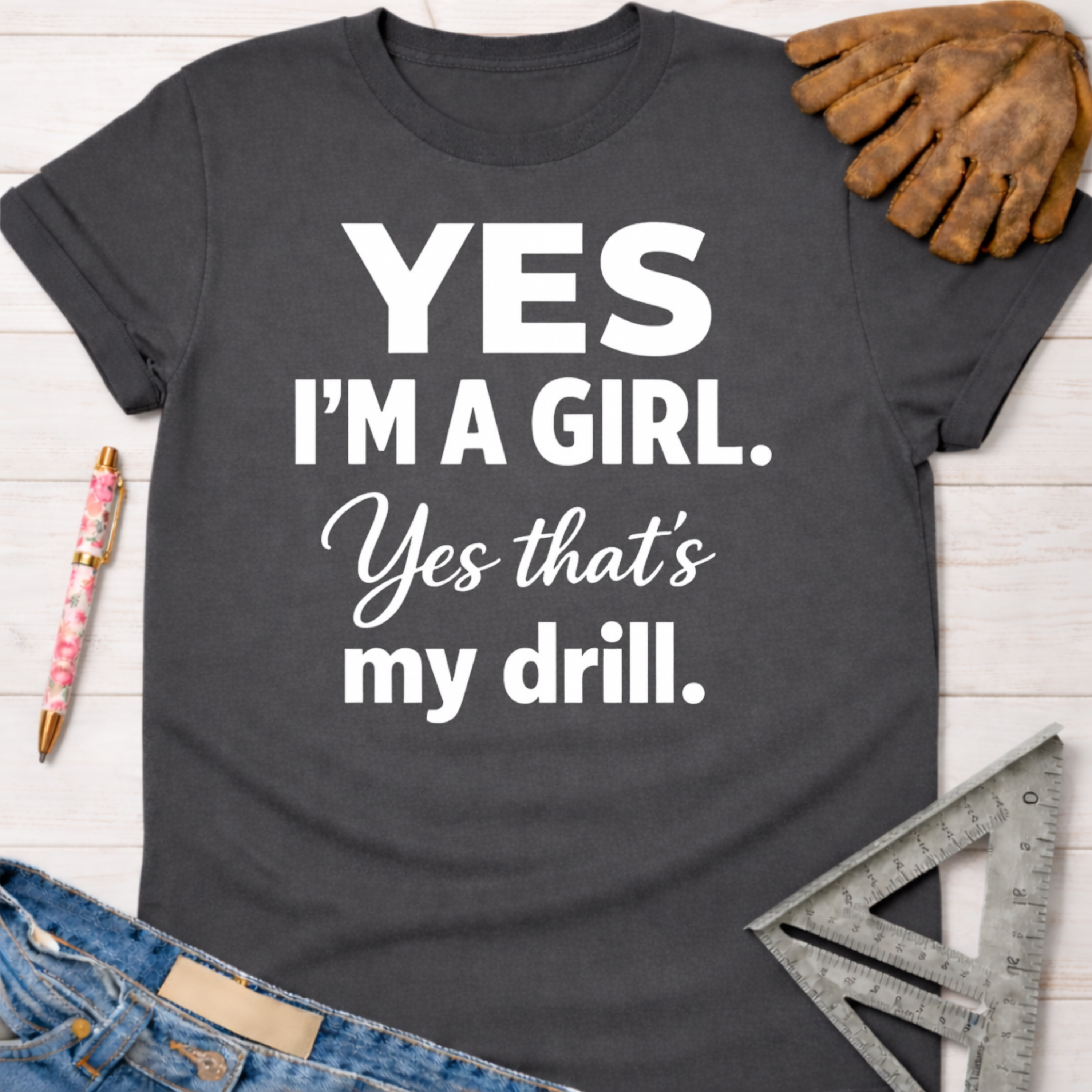 Women's funny woodworking graphic tee shirt for female woodworkers, makers, and DIY builders — Sawdust & Ponytails. Dark gray cotton tee with "YES I'M A GIRL. Yes that's my drill." in white text.