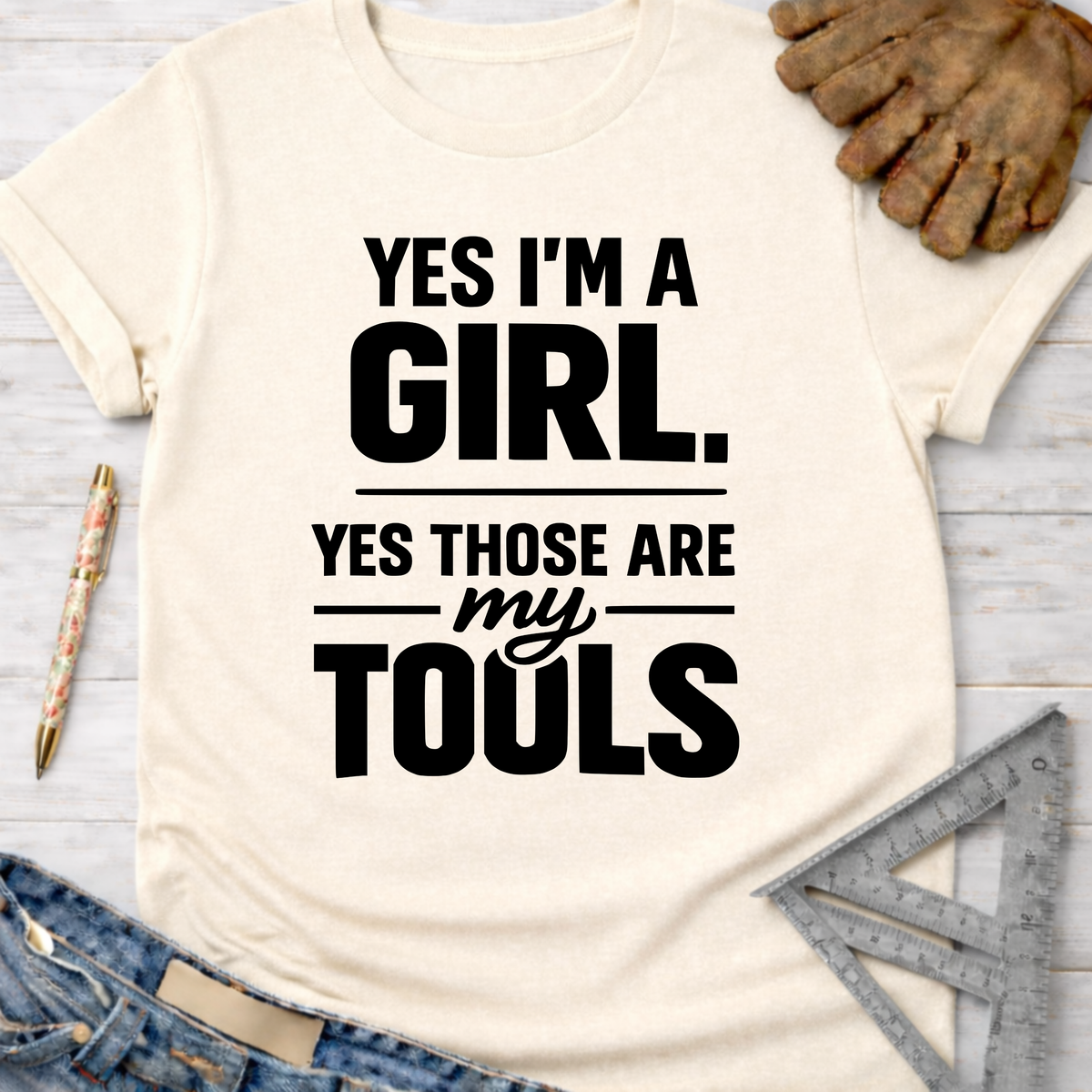 Women's funny woodworking graphic tee shirt for female woodworkers, makers, and DIY builders — Sawdust & Ponytails. Cream t-shirt with "YES I'M A GIRL. YES THOSE ARE MY TOOLS" in black text.