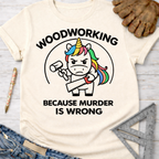 Women's funny woodworking graphic tee shirt for female woodworkers, makers, and DIY builders — Sawdust & Ponytails. Cream t-shirt with a murderous unicorn holding a hammer and saw, text "WOODWORKING BECAUSE MURDER IS WRONG".
